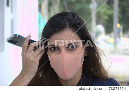 latin woman whit pitta mask listening a voice message in the phone 78873814