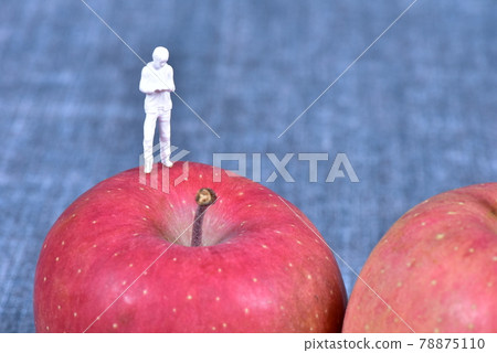 Doll standing on an apple Doll standing on an apple 78875110