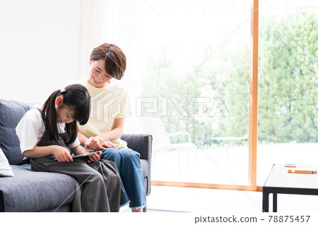 在網上學習的女孩旁邊的母親支持 78875457