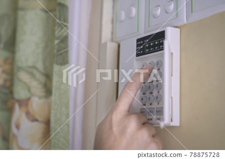Woman entering code pin on home alarm system keypad. Woman entering code pin on home alarm system keypad. 78875728