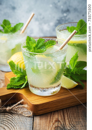 Two glass with lemonade or mojito cocktail with lemon and mint, cold refreshing drink or beverage with ice on rustic blue background Two glass with lemonade or mojito cocktail with lemon and mint, cold refreshing drink or beverage with ice on rustic blue background 78875800