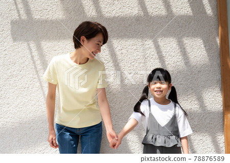 Girl and mother holding hands while basking in the sun 78876589
