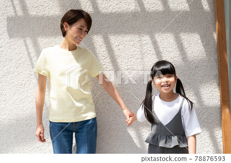 Girl and mother holding hands while basking in the sun 78876593