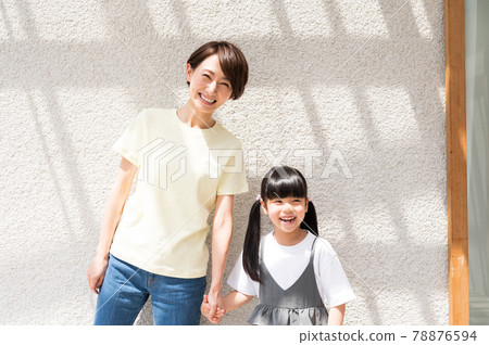Girl and mother holding hands while basking in the sun 78876594
