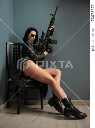 a slender brunette woman in a leather raincoat wearing sunglasses and carrying an American automatic rifle with a telescopic sight a slender brunette woman in a leather raincoat wearing sunglasses and carrying an American automatic rifle with a telescopic sight 78878573