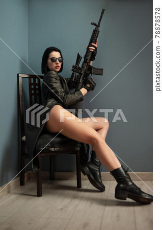a slender brunette woman in a leather raincoat wearing sunglasses and carrying an American automatic rifle with a telescopic sight a slender brunette woman in a leather raincoat wearing sunglasses and carrying an American automatic rifle with a telescopic sight 78878578