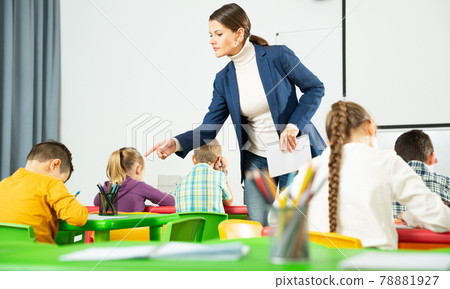 Little children working with teacher in classroom Little children working with teacher in classroom 78881927