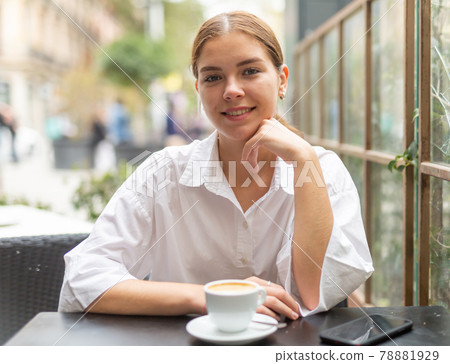 Young attractive girl drinking coffee in cafe Young attractive girl drinking coffee in cafe 78881929