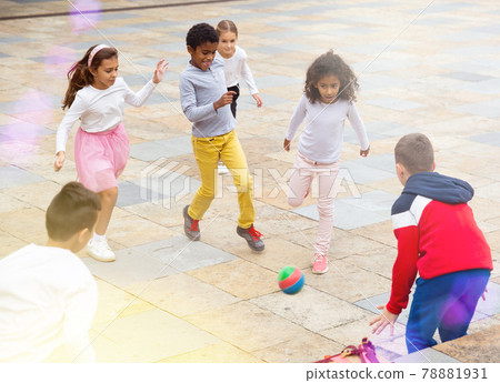 Group of happy schoolchildren playing football together Group of happy schoolchildren playing football together 78881931