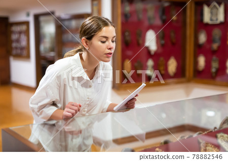 Woman looking at exhibits in glazed stands in museum 78882546