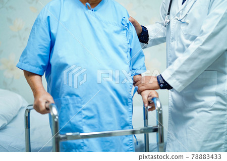 Asian nurse physiotherapist doctor care, help and support senior or elderly old lady woman patient walk with walker at hospital ward : healthy strong medical concept.. 78883433