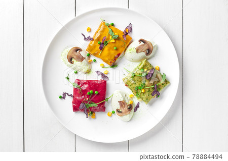 Spinach, carrot and beetroot crepes with mushrooms, cheese and cream filling 78884494