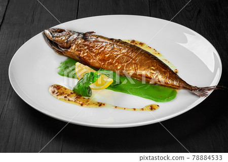 Grilled mackerel with green pea puree, herbal sauce and lemon 78884533