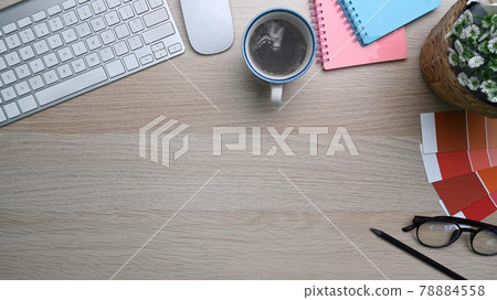 Designer workspace with keyboard, coffee cup, glasses and notebook on wooden table. Designer workspace with keyboard, coffee cup, glasses and notebook on wooden table. 78884558