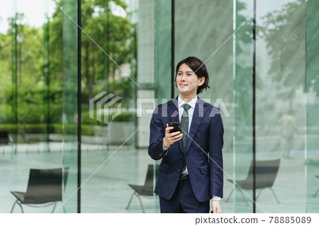Young men coming to work ・ IoT / business image with smartphones 78885089
