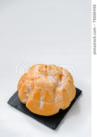 Sweet bun with cream on a shale dishes and wooden background. Sweet bun with cream on a shale dishes and wooden background. 78886498