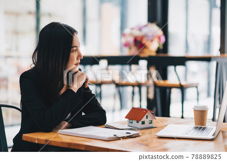 Shot of Estate agent working at her office. Businesswoman using laptop computer 78889825