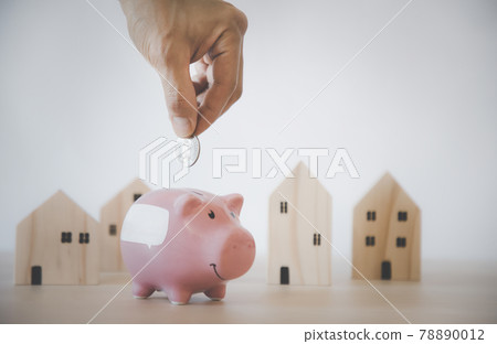 Hand hold Coins and pink piggy with icon business with Mini wood house model from model on wood table, Planning buy Real Estate, Planning to buy property and Choose the best, saving money concept. Hand hold Coins and pink piggy with icon business with Mini wood house model from model on wood table, Planning buy Real Estate, Planning to buy property and Choose the best, saving money concept. 78890012