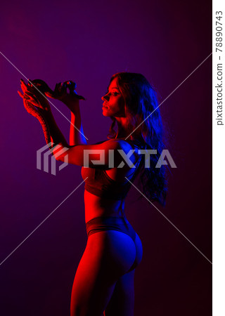 Beautiful young redhead woman with a snake with a fashionable perfect makeup. Studio shot 78890743