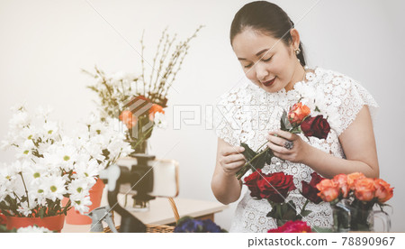 Online home flower arrangement concept, Woman Preparing to trim red and pink roses and beautiful flower arrangements in the home, flower arrangements with vase for gift-giving for Valentine's Day 78890967