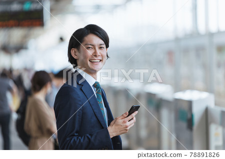 Image of young man commuting and IoT with a smartphone at the platform of the station Image of young man commuting and IoT with a smartphone at the platform of the station 78891826