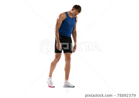 Caucasian professional male athlete, runner standing isolated on white studio background. Muscular, sportive man. 78892379