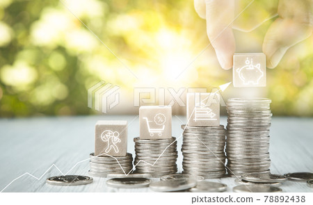 Close up of male hand stacking coins and Trees growing on coin in dark background ,Business Finance and Money, plant growing up on coins and investment budget, saving money investment.concept 78892438