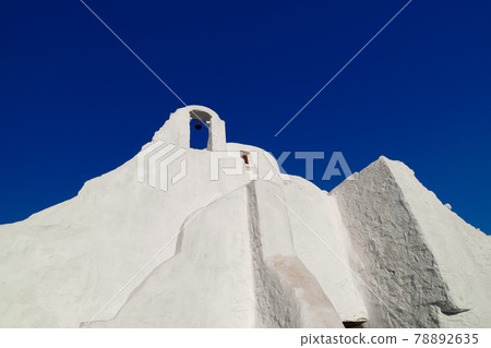 Famous tourist landmark, Mykonos island, Greece. White Greek Orthodox church of Panagia Paraportiani at sunrise. Upshot, white church, deep blue sky Famous tourist landmark, Mykonos island, Greece. White Greek Orthodox church of Panagia Paraportiani at sunrise. Upshot, white church, deep blue sky 78892635