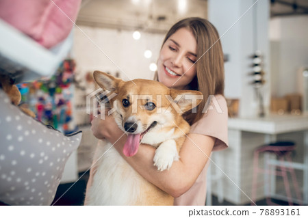 A smiling girl choosing animal accessories in a pet shop 78893161