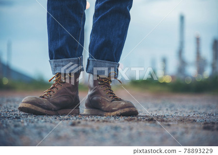 Men wear construction Boots safety footwear for worker at construction site. Engineer Wear Jeans Brown Boots Worker on Background of Refinery. Engineer safety industry fashion footwear walking outdoor 78893229