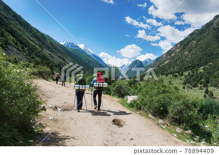Idyllic winter landscape with hiking people in the mountains. Rocks, snow and stones in mountain valley view. Mountain panorama. Idyllic winter landscape with hiking people in the mountains. Rocks, snow and stones in mountain valley view. Mountain panorama. 78894409