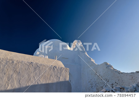 Famous tourist landmark, Mykonos island, Greece. White Greek Orthodox church of Panagia Paraportiani at sunrise. Upshot, white church, deep blue sky Famous tourist landmark, Mykonos island, Greece. White Greek Orthodox church of Panagia Paraportiani at sunrise. Upshot, white church, deep blue sky 78894457