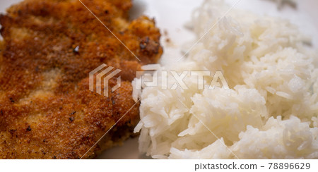 Simple home cooking for a bachelor from a breaded and pan-fried escalope of white boiled rice, simple dish 78896629