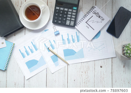 financial graph, calculator and notepad on table  78897603