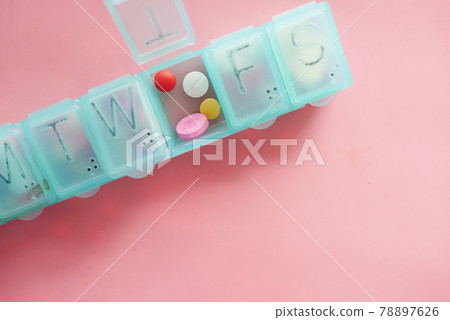 medical pills and capsule in a pill box on pink background medical pills and capsule in a pill box on pink background 78897626