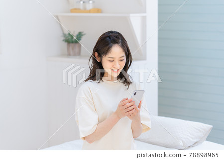 在床上使用智能手機的年輕女子 78898965