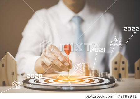 Targeting the business and 2022 concept, Businessman touch red arrow dart to the virtual target dartboard, Executive marketing, investment goal and target for business investment concept, mini home. 78898981