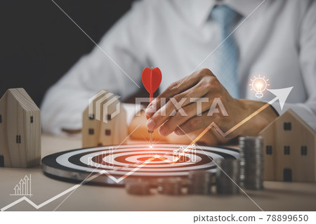 Targeting the business concept, Businessman touch red arrow dart to virtual target dart board,Executive marketing, investment goal and target for business investment concept, mini home and Coins stack 78899650