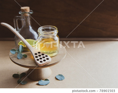 蜂蜜、蜂蜜和蜂巢蜂蜜浸入玻璃罐中 78901503