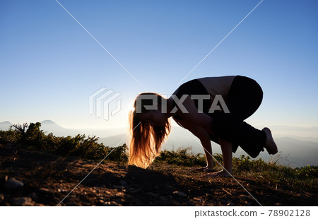 Woman is practicing yoga in Firefly pose. 78902128