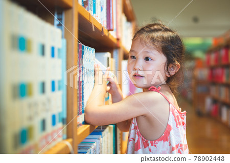 Girl choosing a book Girl choosing a book 78902448