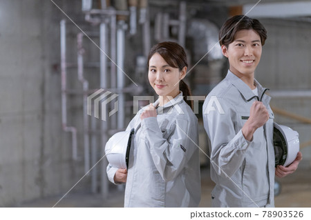 Portrait of two workers standing with helmets at the construction site 78903526