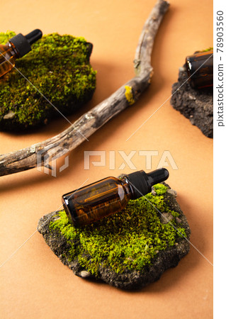 Bottles of cosmetic product on concrete stone with moss and wooden branch on beige background Bottles of cosmetic product on concrete stone with moss and wooden branch on beige background 78903560