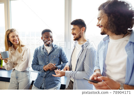 Cheerful young business people have a talk during coffee break in office Cheerful young business people have a talk during coffee break in office 78904171