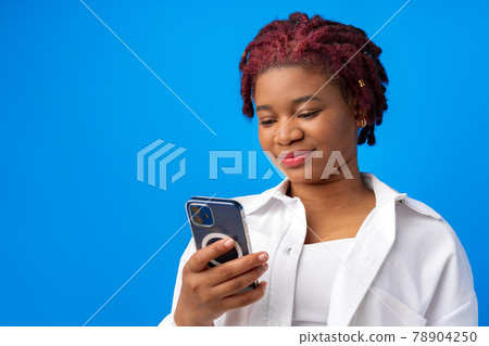African american woman using smartphone against blue background African american woman using smartphone against blue background 78904250