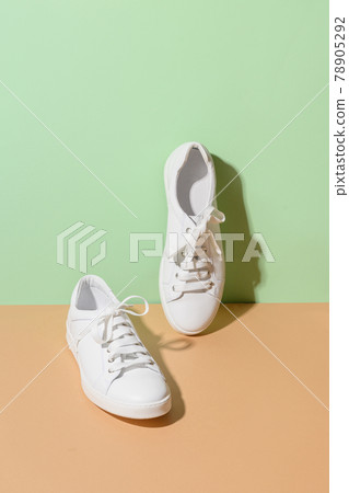 White female gumshoes on a beige background. 78905292