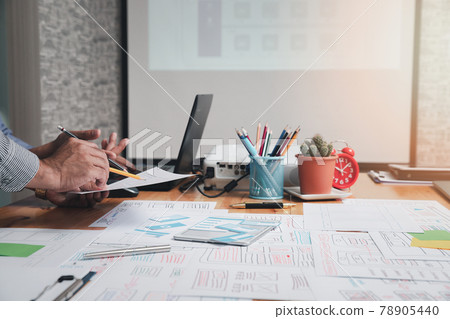 UX or UI designers designing on their smartphone application layout prototype project. UX or UI designers designing on their smartphone application layout prototype project. 78905440