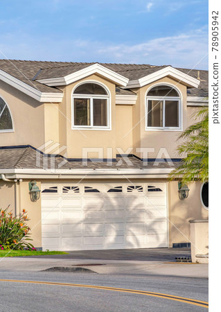 Home exterior with attached garage and dormers on gray roof in Huntington Beach 78905942
