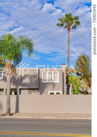 Home with flat roof and concrete fence along road in Huntington Beach California 78905949