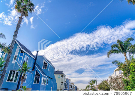 Looking up to vibrant blue sky with puffy clouds over houses in Huntington Beach Looking up to vibrant blue sky with puffy clouds over houses in Huntington Beach 78905967